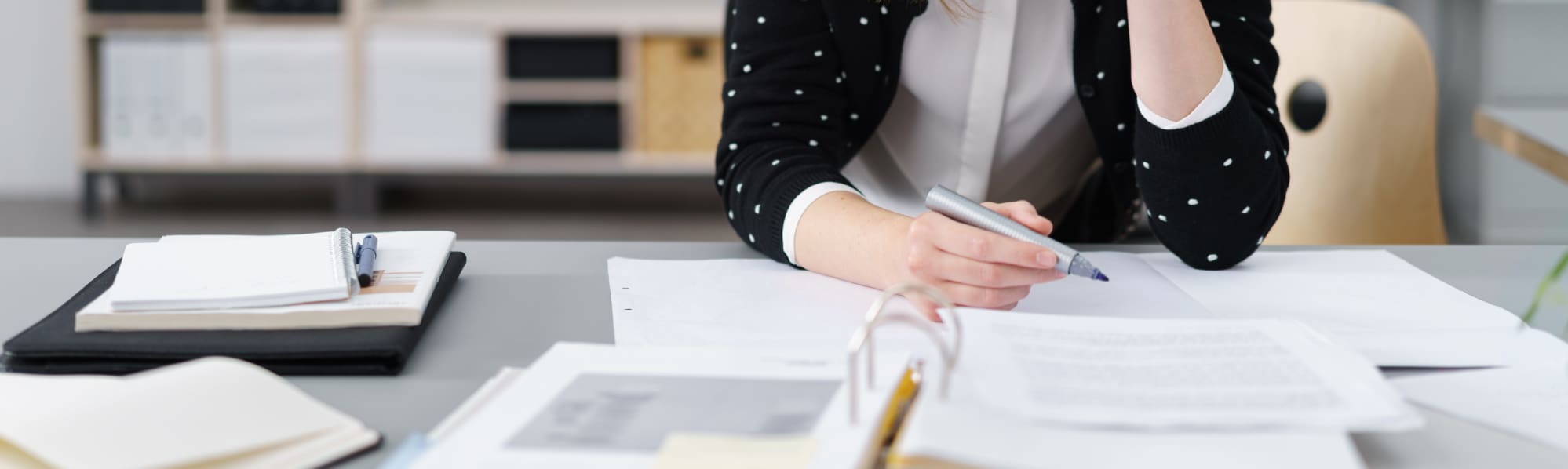 Someone proof reading an official document, holding a marker pen