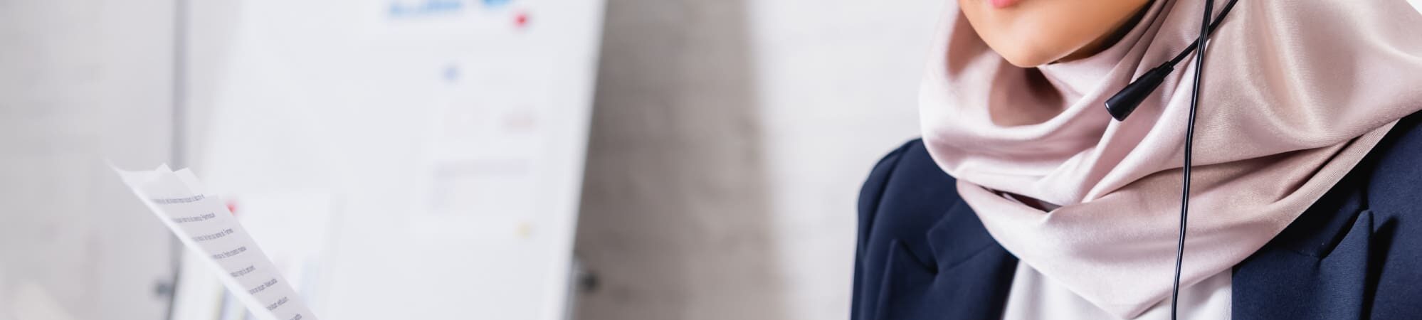 Woman wearing a headdress and microphone, translating a document.