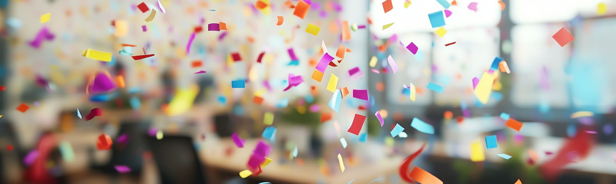 Colourful confetti falling in a business function room with a blurred background.