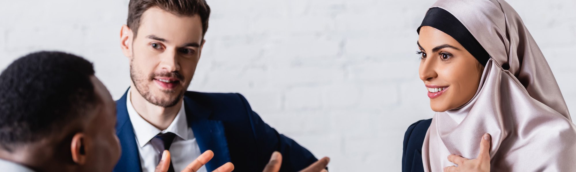 3 people sat round a table, one person is translating the conversation.