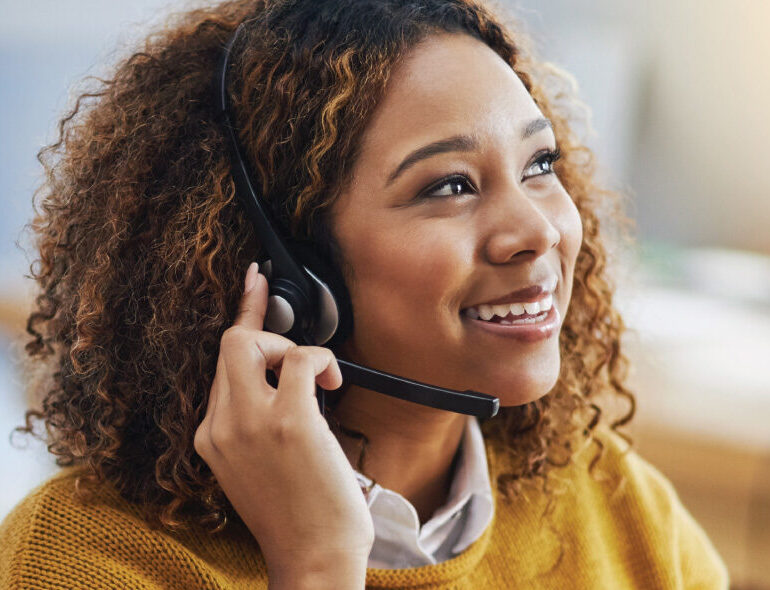 Person wearing a headset speaks while seated indoors in a workspace.