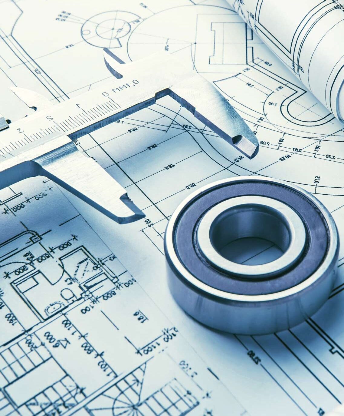 Bearing and calliper placed on detailed engineering drawings with measurements visible.
